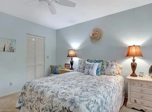 Bedroom featuring light carpet, a closet, and a ceiling fan