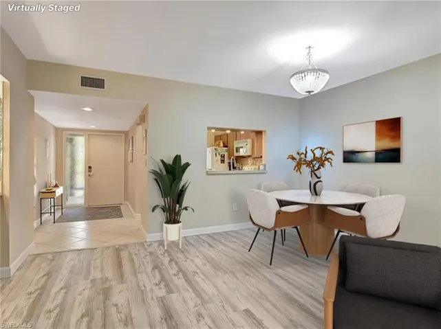 Dining area with light wood-style flooring and a chandelier