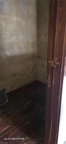 Unfurnished room with dark wood-style flooring and baseboards