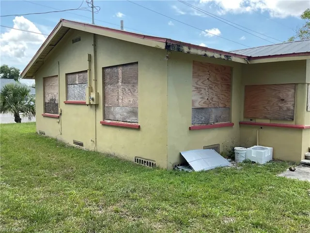View of property exterior with stucco siding, a yard, and crawl space