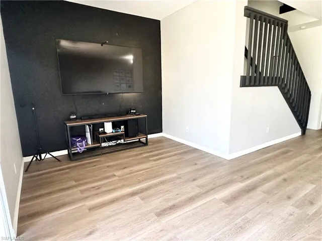 Living area with stairway and light wood-style floors