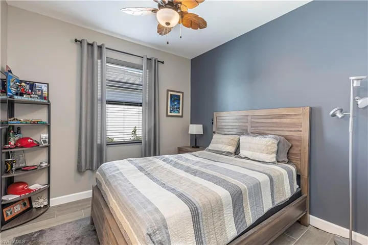Bedroom featuring ceiling fan, baseboards, and wood finished floors