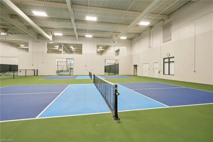 View of tennis court featuring community basketball court and fence