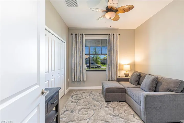 Living room featuring baseboards, visible vents, and ceiling fan