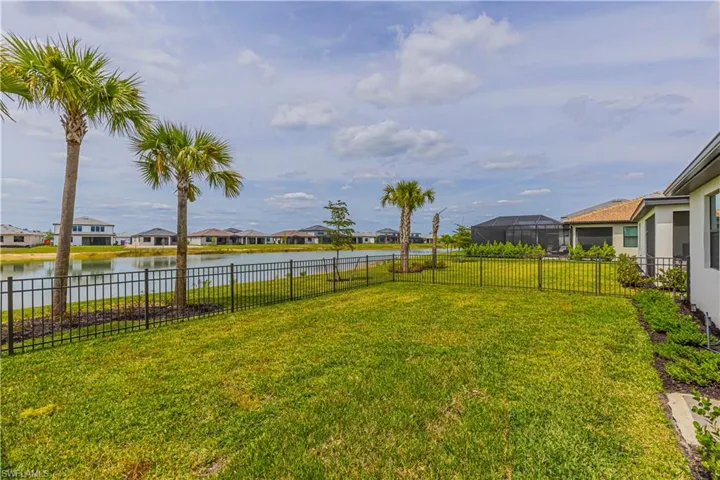 View of yard featuring a fenced backyard, a residential view, and a water view