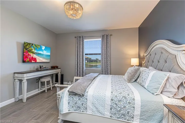 Bedroom with wood finished floors, baseboards, and a chandelier