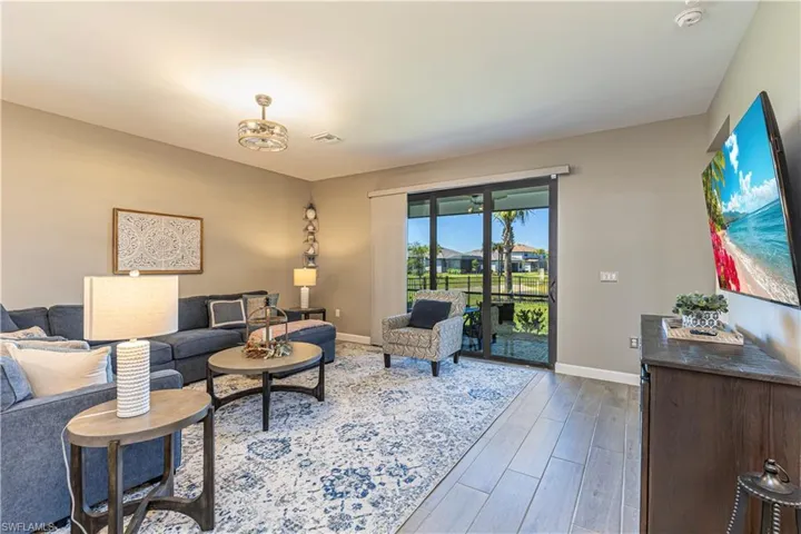 Living room with wood finished floors, visible vents, and baseboards