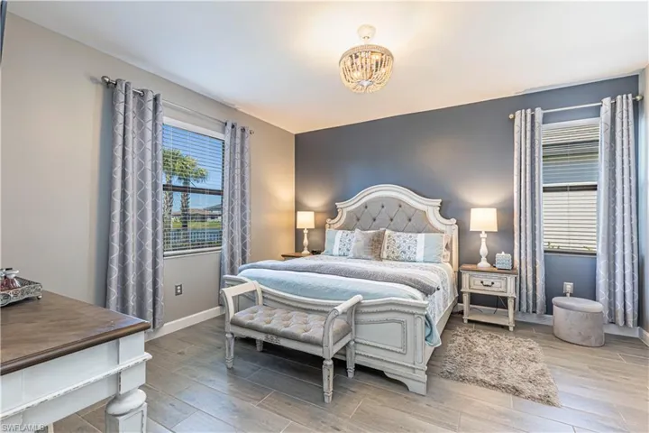 Bedroom featuring wood finish floors, baseboards, and an inviting chandelier