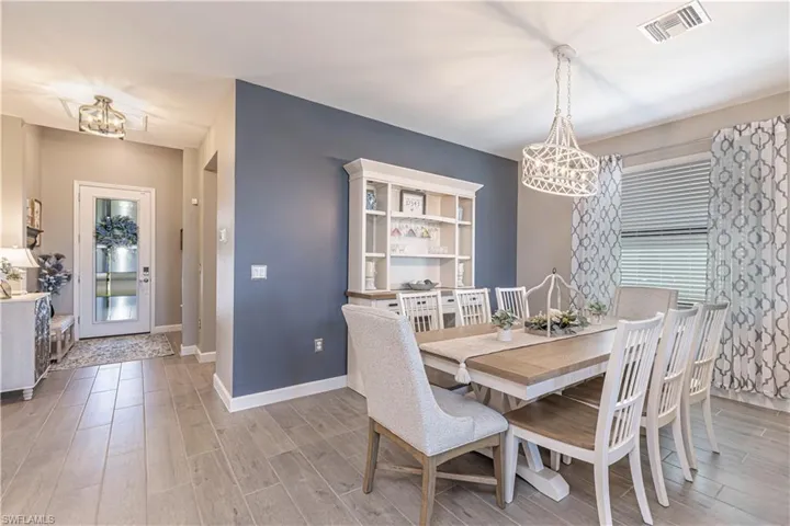 Dining area featuring visible vents, baseboards, an inviting chandelier, and wood finished floors