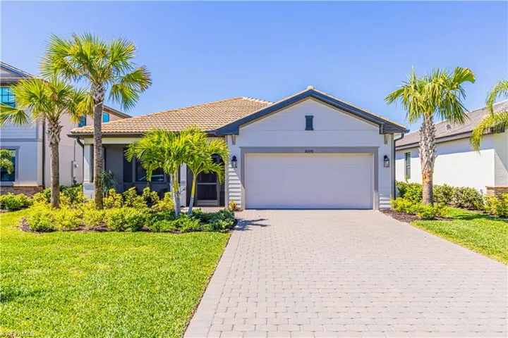 Ranch-style house with decorative driveway, a front lawn, an attached garage, and a tiled roof
