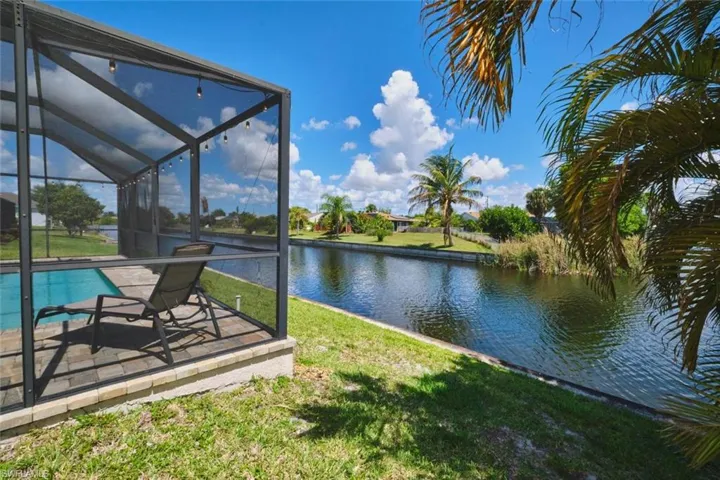Screened lanai featuring a swimming pool, paver deck, and direct canal access