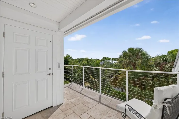 Outdoor patio featuring a paneled door, recessed lighting, tile flooring, and metal cable railing