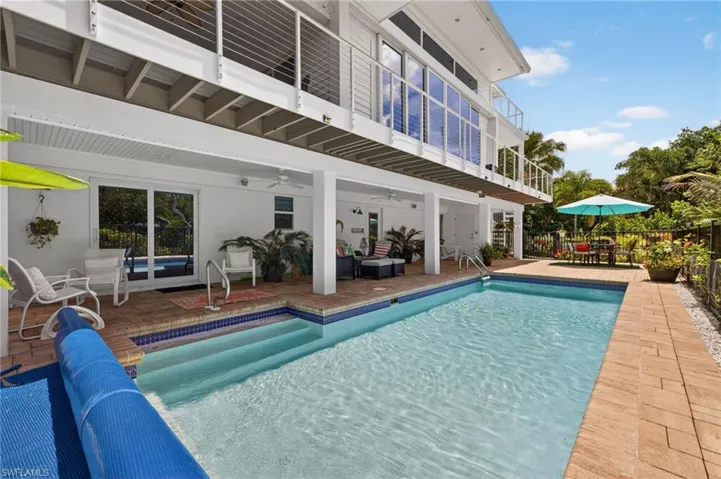 Rectangular swimming pool with integrated steps, surrounded by brick paver decking
