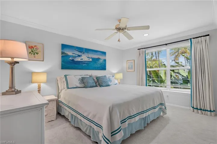 Recessed lighting, crown molding, ceiling fan, large window with blinds, and light-colored carpeting