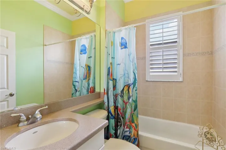 Bathroom featuring shower / bath combination with curtain and vanity