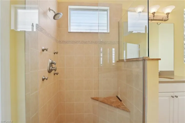 Full bathroom featuring a walk in shower, vanity, and a chandelier