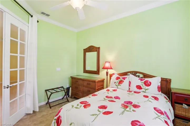 Bedroom with crown molding, a ceiling fan, and light colored carpet