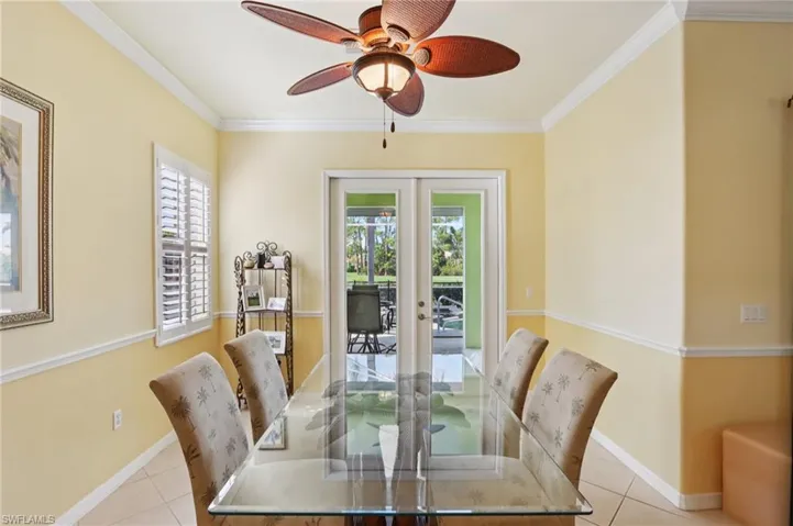 Dining room featuring french doors, light tile patterned flooring, crown molding, and ceiling fan