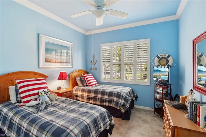 Bedroom with crown molding, ceiling fan, and tile patterned floors