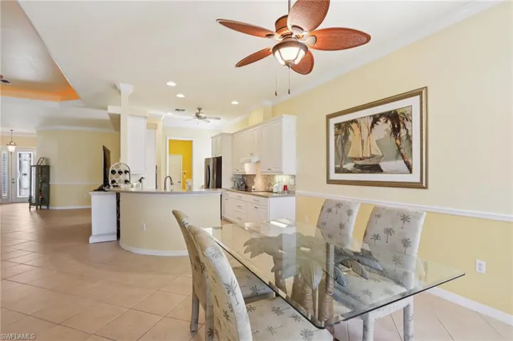 Dining area featuring ornamental molding, light tile patterned floors, recessed lighting, and a ceiling fan