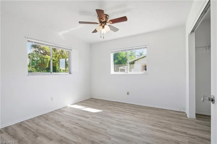 Unfurnished bedroom with a closet, light wood-style flooring, and a ceiling fan