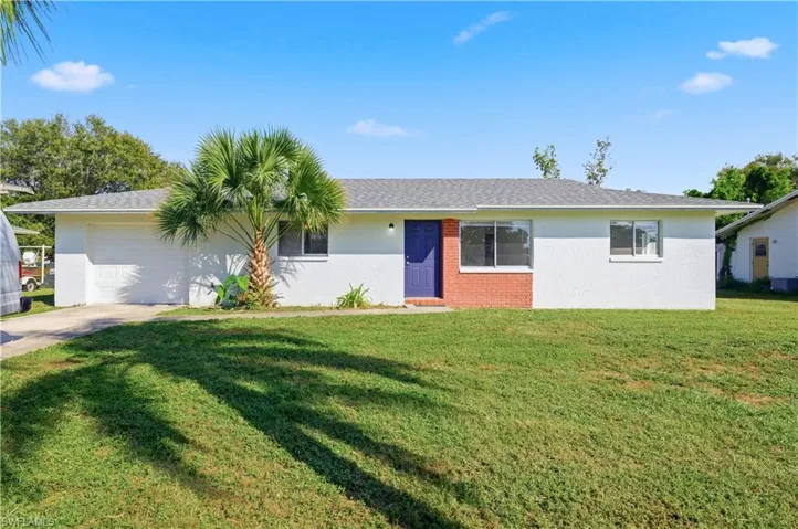 Single story home with a garage, a front lawn, concrete driveway, stucco siding, and brick siding