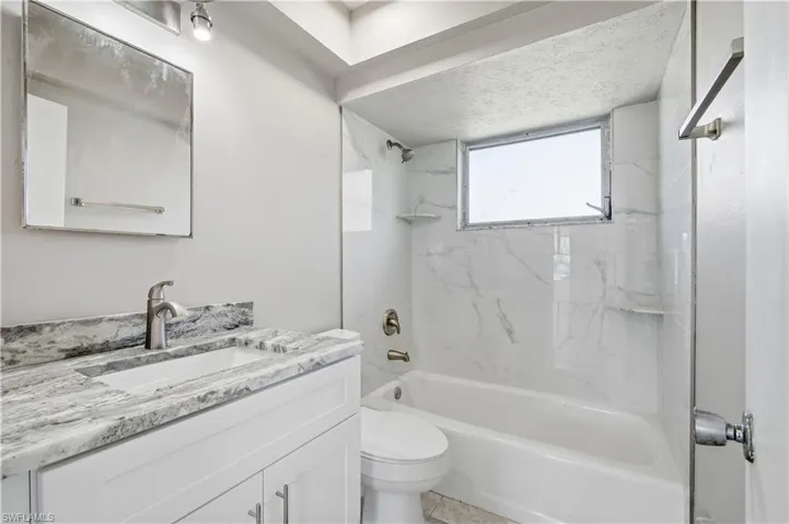 Bathroom with shower / bath combination and vanity