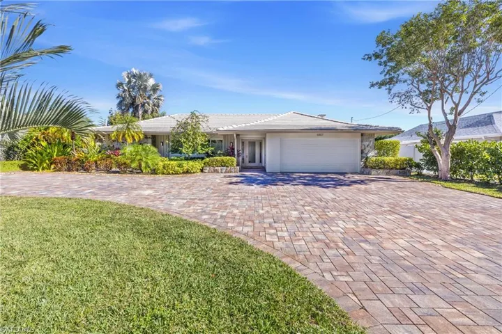 Ranch-style home with a decorative paver driveway and a 2 car garage