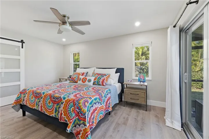 Primary Bedroom featuring Sliding Glass Doors to the Screened Pool Lanai