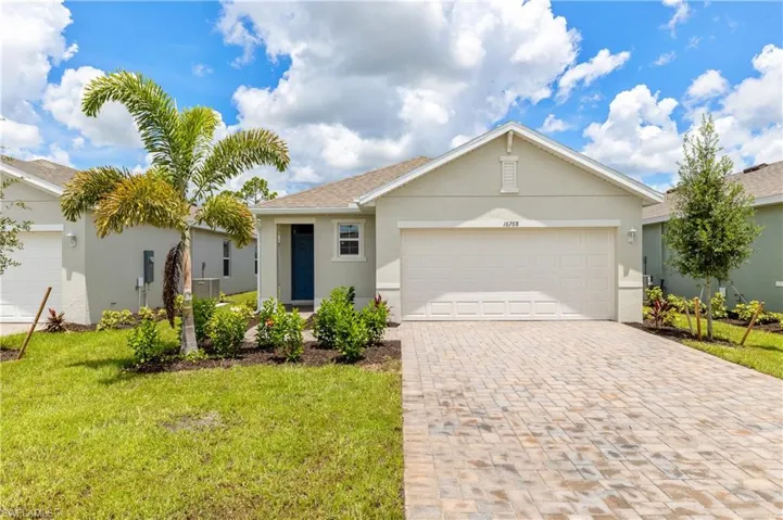 Ranch-style house with stucco siding, a front lawn, decorative driveway, and a garage