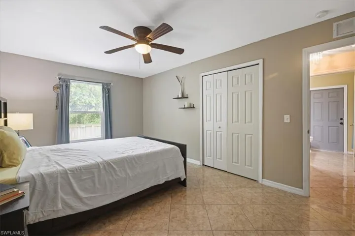 Tiled bedroom with baseboards, a closet, and ceiling fan