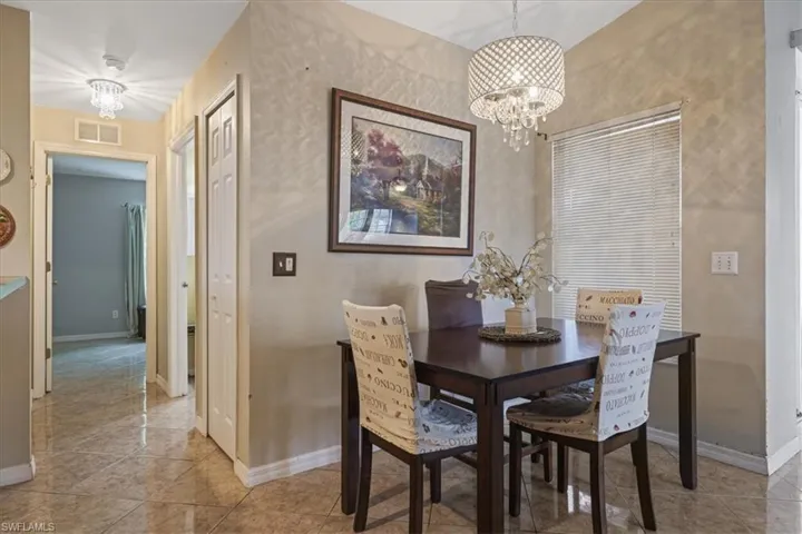 Dining room featuring a chandelier, baseboards, and light tile patterned flooring