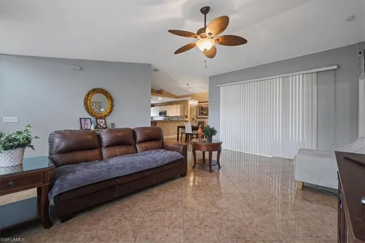 Living room featuring ceiling fan and vaulted ceiling