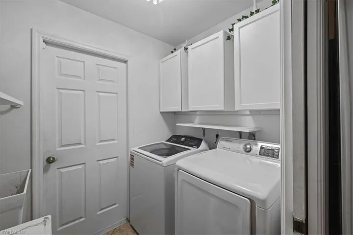 Laundry area with cabinet space and washer and clothes dryer