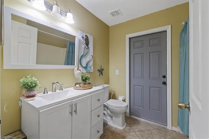 Bathroom featuring toilet, vanity, and tile patterned flooring