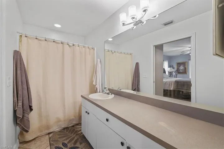 Full bath with vanity, ensuite bathroom, recessed lighting, a chandelier, and tile patterned floors