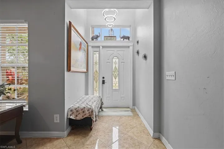 Entryway featuring light tile patterned floors and baseboards