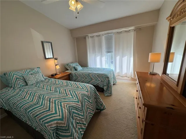 Carpeted bedroom featuring ceiling fan