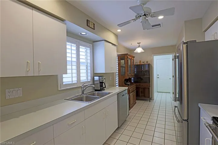 Kitchen featuring appliances with stainless steel finishes, white cabinets, light countertops, light tile patterned flooring, and recessed lighting