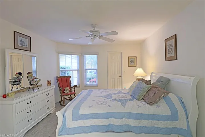 Carpeted bedroom featuring a ceiling fan