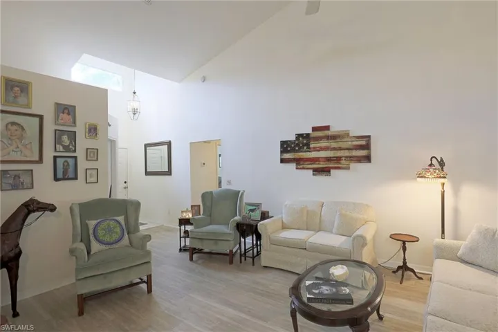 Living room with wood vinyl flooring  and high vaulted ceiling