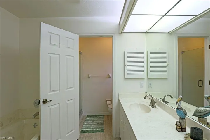 Bathroom featuring vanity, a stall shower, a tub, and tile floors