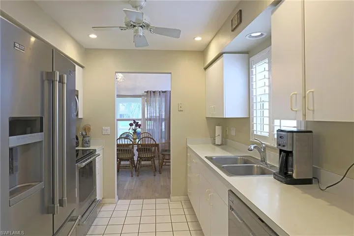 Kitchen featuring appliances with stainless steel finishes, a ceiling fan, white cabinets, light countertops, and recessed lighting
