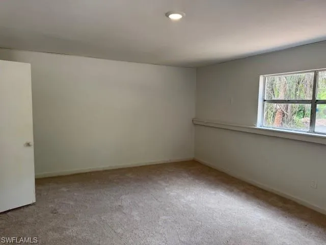Spare room featuring carpet floors and baseboards