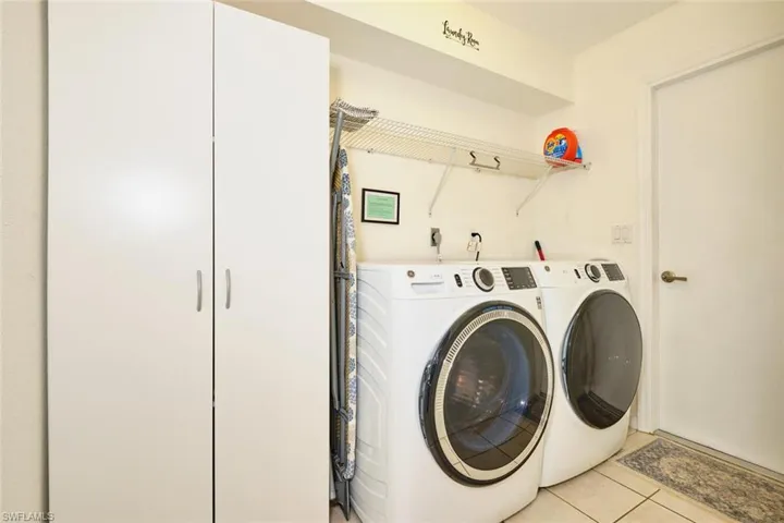 Laundry area featuring light tile patterned floors and independent washer and dryer