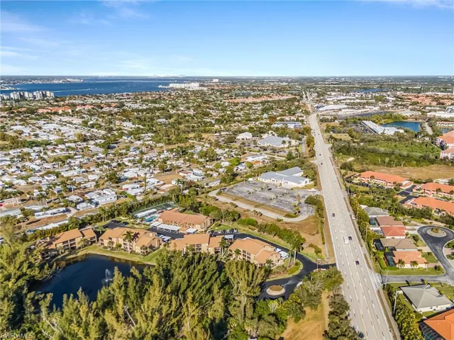Aerial view of property and surrounding area with a nearby body of water and nearby suburban area