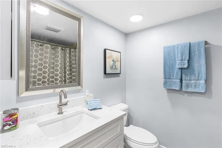 Bathroom featuring a shower with curtain and vanity