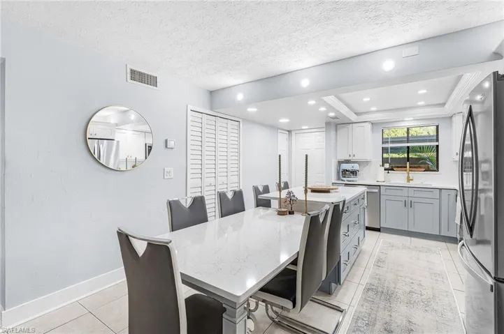Kitchen featuring stainless steel appliances, light stone counters, a center island, recessed lighting, and light tile patterned floors