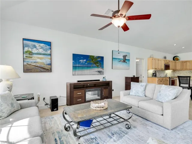 Living room with lofted ceiling and a ceiling fan