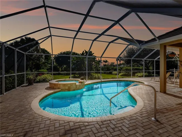 View of pool featuring a sunroom, a patio area, glass enclosure, and a pool with connected hot tub
